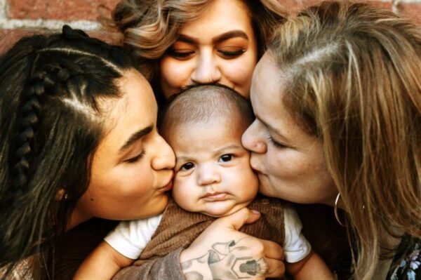 Generations of woman from one family kissing baby